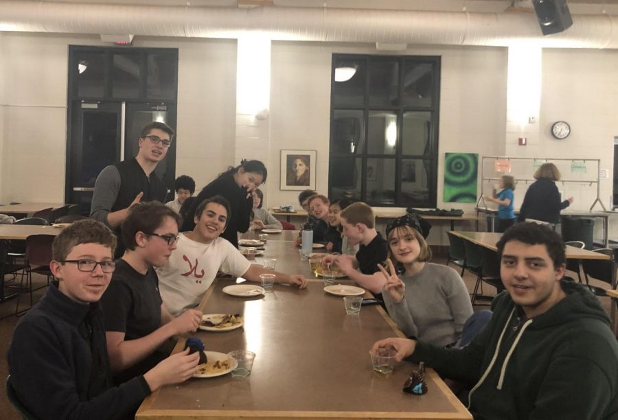 The fencing team gathers around a dining hall table while sharing a banquet dinner.