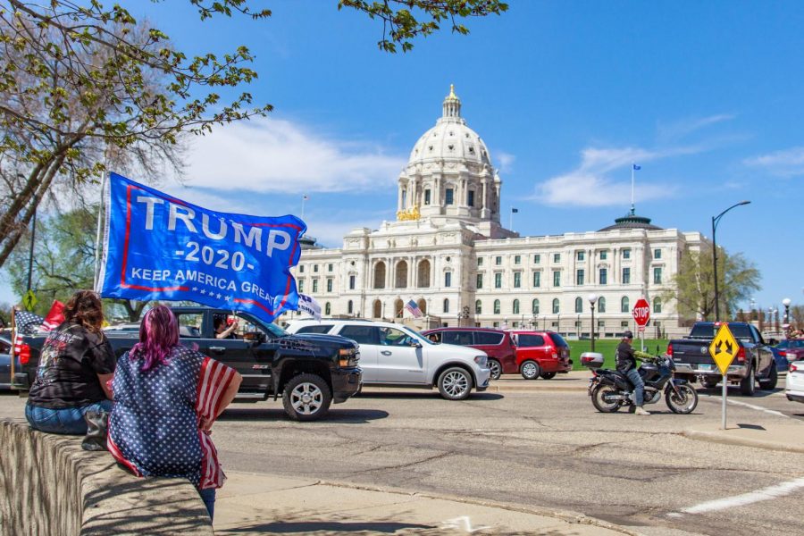 A protestor holds a pro-Trump flag as vehicles surround the Minnesota State Capitol in protest of Gov. Tim Walzs efforts to combat the coronavirus pandemic. May 2, 2020.