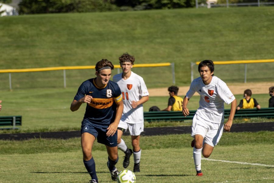 Senior Michael Bagnoli dribblings the soccer ball around defenders