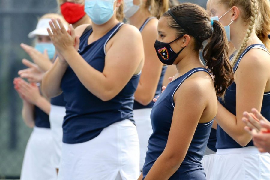 Audrey Senaratna steps forward, acknowledging herself to her opponent during line ups, a time when tennis players would usually introduce themselves by shaking their opponents hand.