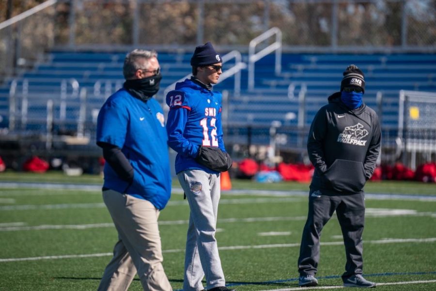 Sidelined quarterback Charlie Johnson observes practice with coaches. He still serves as captain of the team, even though his injury prevents him from playing: “My role has changed as a player but not a leader. Being a captain of the team I am helping all of our guys prepare as well as talking and game-planning with coaches, I am still every part of this team just as I was before, now the only difference is I cant suit up and put the pads on every Friday night,” Johnson said.