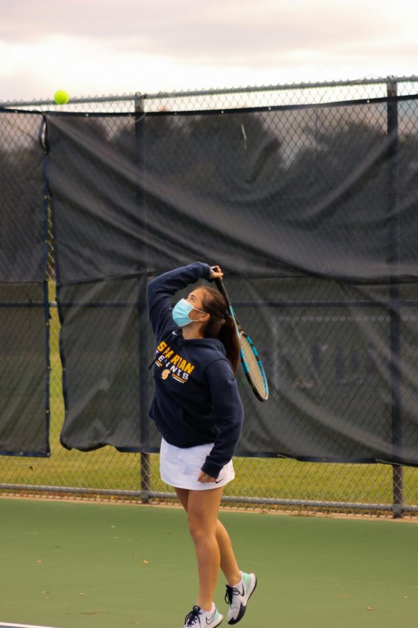 Senior Maya Choi warms up with her mask on before the game.