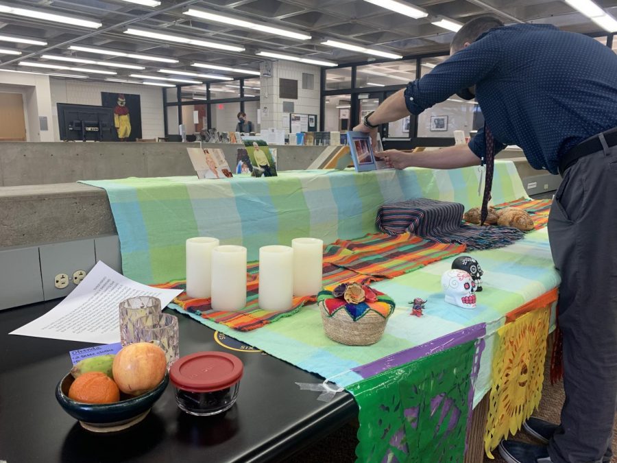 Upper School Principal Max Delgado places a photo of a loved one on the ofrenda.