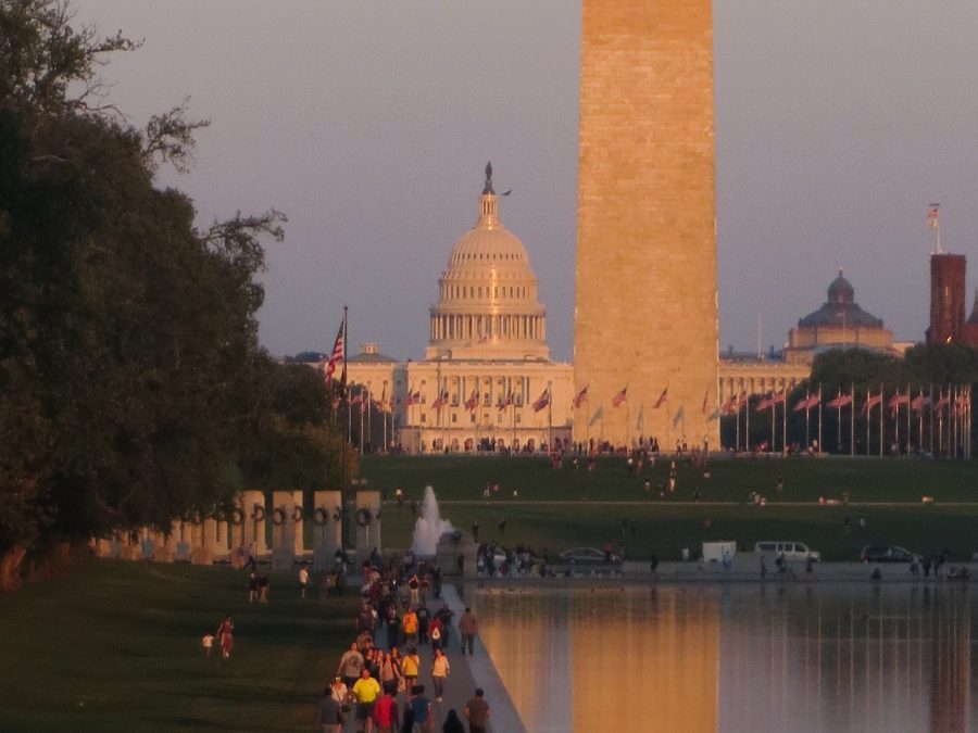 The sun sets on the U.S. Capitol and Washington Monument, which reflect in the Lincoln Memorial Reflecting Pool in Washington, D.C. Photo by Nikolas Liepins.
