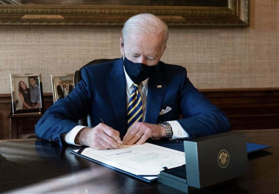 President Biden signing executive orders within the first days of his term in office.