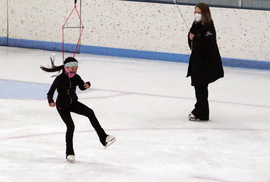 Warne-Jacobsen uses the same method she used to train Chen earlier, using the harness to let Chen practice spinning in the air on ice.