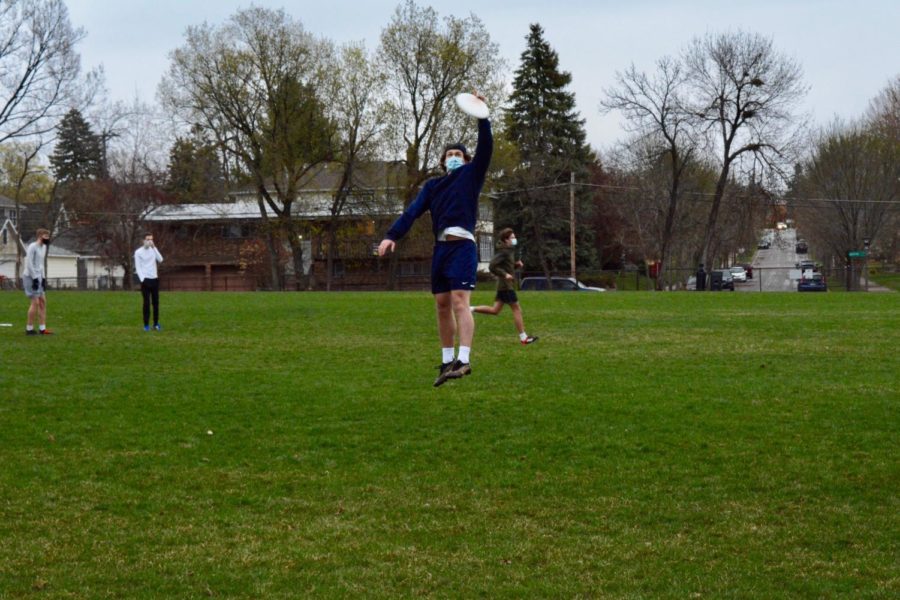 During practice, senior Jackson Biggs jumps to catch the frisbee midair.