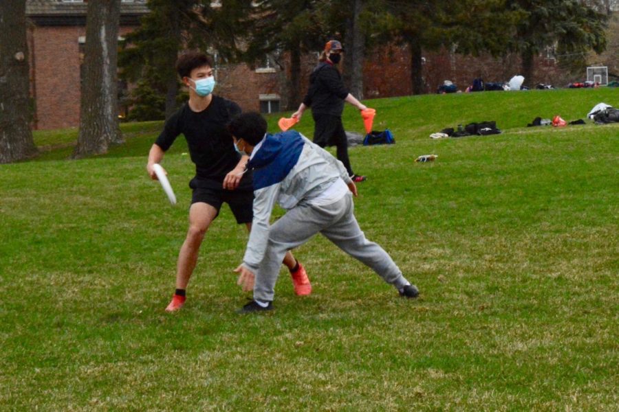 Sophomore Ben Chen tries to get frisbee around junior Pah Na during practice.