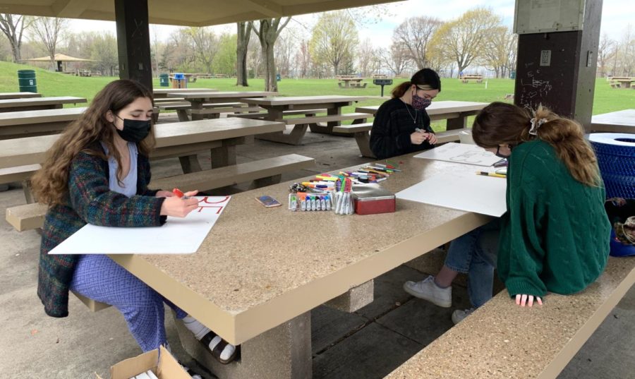 Students make colorful signs protesting the oil pipeline Line 3 to be placed on student's  lawns.  