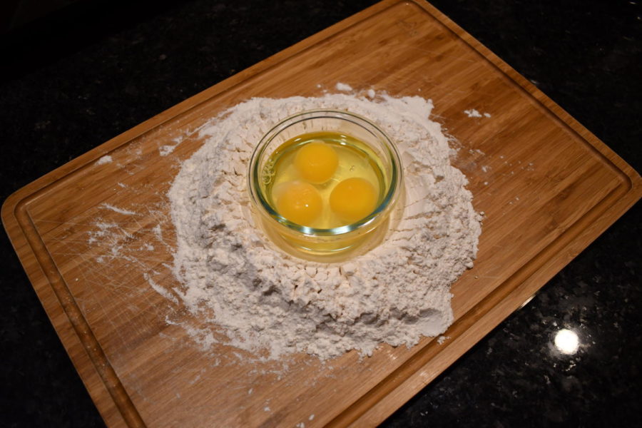 This image shows one of the first stages of making pasta. Eventually, these eggs and flower will create tasty pasta!