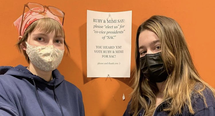 Sophomores Ruby and Mimi showing their campaign poster in the hallways. We decided to use instagram because we knew we could reach more people, such as incoming 8th graders who we might not know, the community and friends outside of SPA really rallied around us to support our campaign said Huelster.