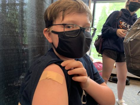7th-grader Howard Huelster shows off his vaccination bandage. [The shot] didn’t really hurt, said Huelster. It felt like a pinch.