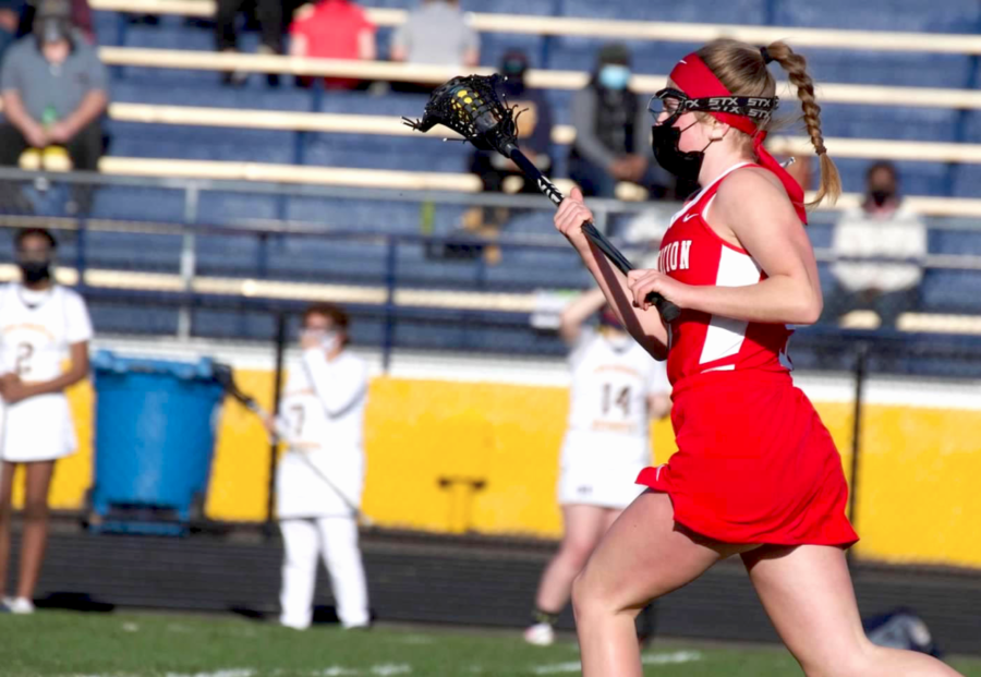 Senior Erin Magnuson cradles the ball during an away game. “I got into both [sports] because my parents played. My mom played lacrosse and suggested [that I] try it, and my dad played hockey, so both my sister and I tried it [too]. I love the intensity of sports and the feeling of accomplishment when I do something well or reach a goal I have set for myself, which is why I really enjoy playing,” Magnuson said.