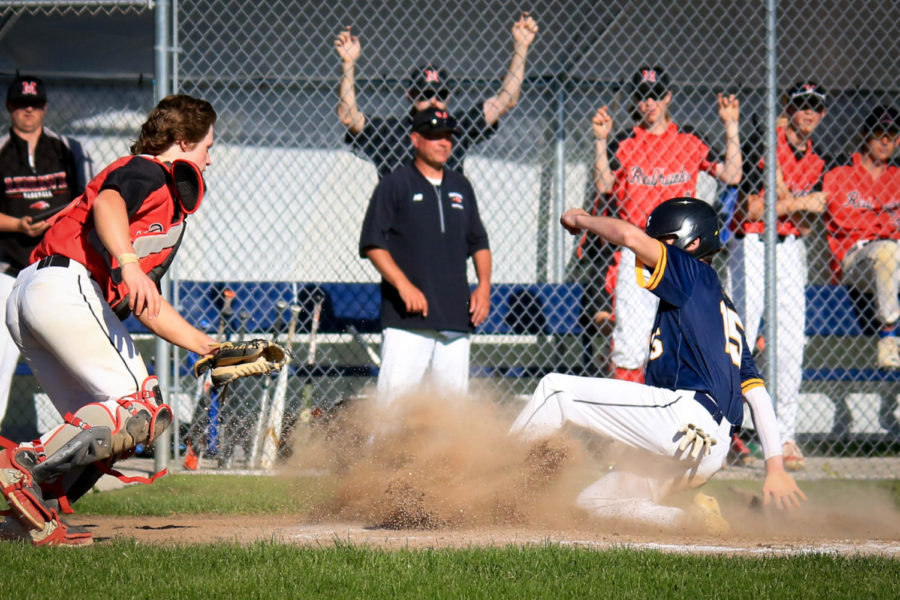 Ninth-grader John Christakos slides onto home base as dust flies around him. Christakos has stepped up for the team, even as a new player, having played in nine games so far this season.