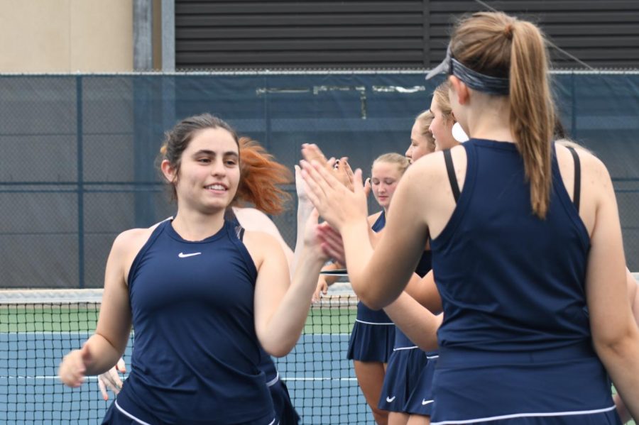 HIGH FIVES. Senior Sonia Ross high fives her teammates before a tough match.