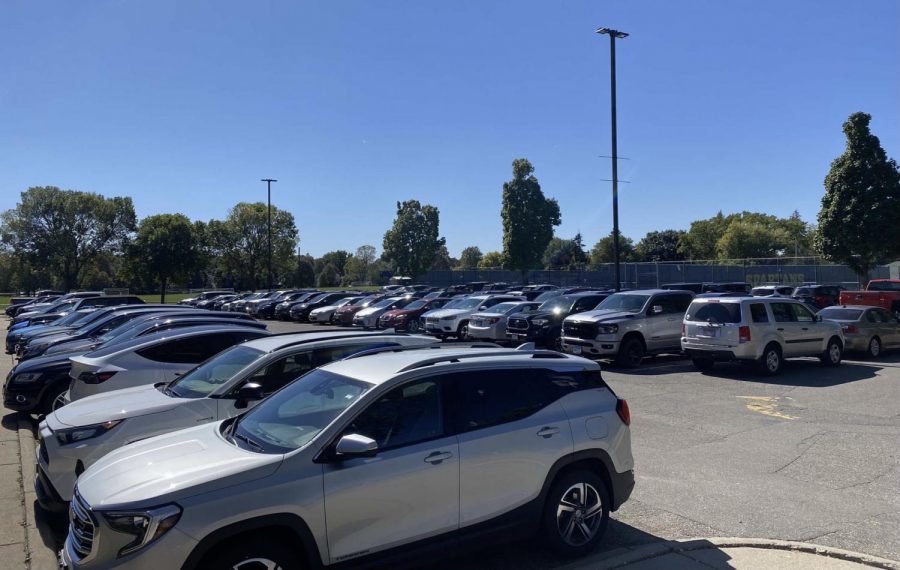 After students wait in the car drop-off line before the school day starts, they often have to park in areas of the Huss and Drake lots that don't have designated parking spots to avoid being late for advisory check-in. 