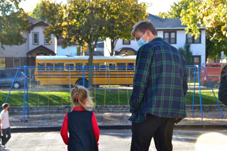  Senior Harry Mahmic and Kindergartener Isabelle, decide the best place to play on the playground. Seniors accompanied their pumpkin carving buddies to recess after making jack o'lanterns .