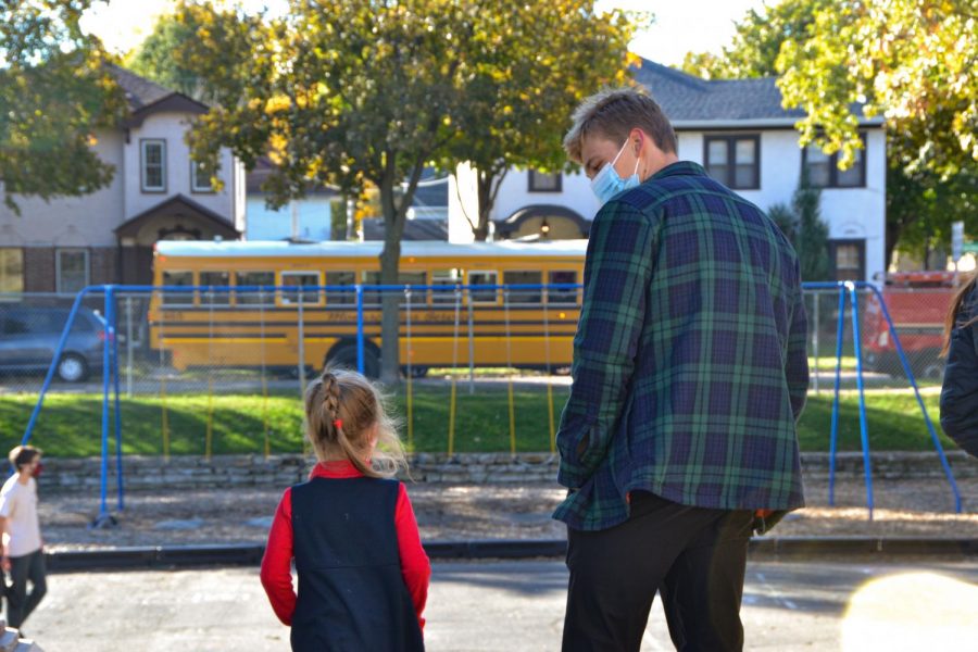  Senior Harry Mahmic and Kindergartener Isabelle, decide the best place to play on the playground. Seniors accompanied their pumpkin carving buddies to recess after making jack olanterns .