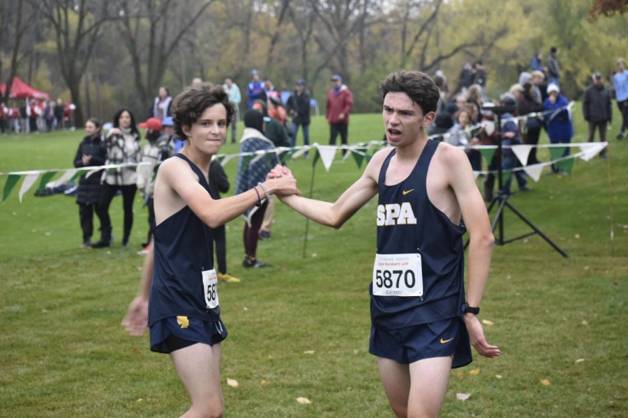Captain Naci Konar-steenberg congratulates sophomore Sandro Fusco on a great race. Konar-steenberg achieved a personal record of 19:14.5 and placing 46th. He said, That was my last race in high school, and I just feel like I did everything I wanted to do.