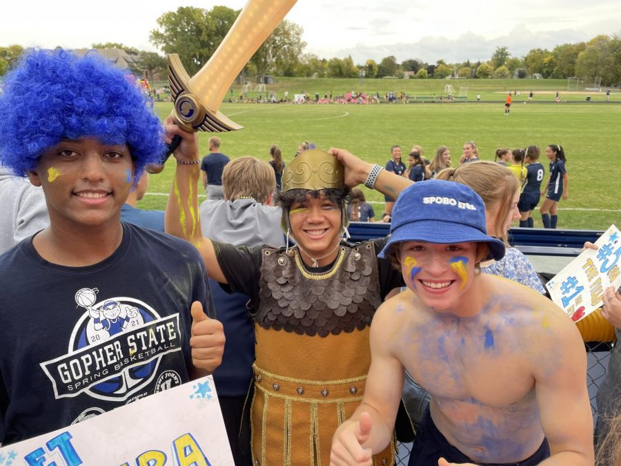 Senior Pah Na and juniors Simon Assefa and Natha Cohen cheer on Girls Varsity Soccer at the Homecoming game.