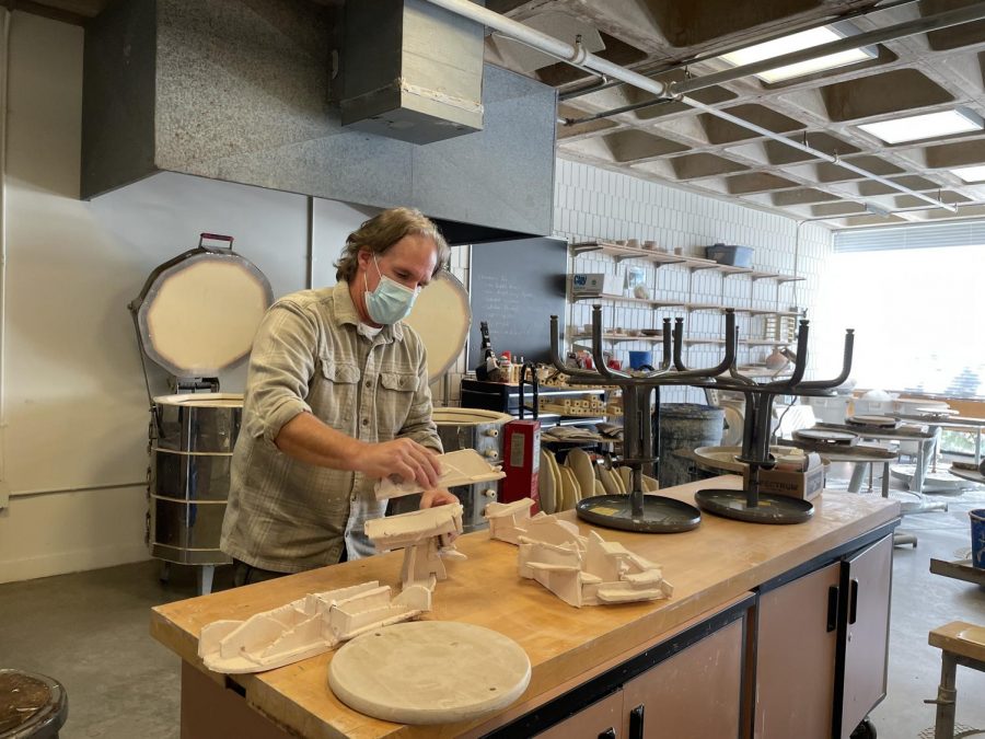 EMBRACE CREATIVITY. Fine arts department chair and ceramics teacher Daryn Lowman works with a piece of pottery in preparation for one of his classes. Lowmans core teaching philosophy includes ideas like this one: it is important to be open-minded when entering the stage or studio because that is when you truly get the most out of an elective.