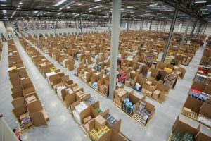 PACKAGED. Amazon is a massive company, shipping products to customers worldwide in their signature cardboard boxes. However, before choosing to buy from Amazon, we should first consider the positives and the negatives, such as the working conditions in a warehouse like this one.