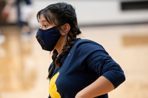 MASK UP. Sophomore Naomi Kempcke warms up before a game last season. At this point in time, both teams were required to wear face masks due to COVID-19.