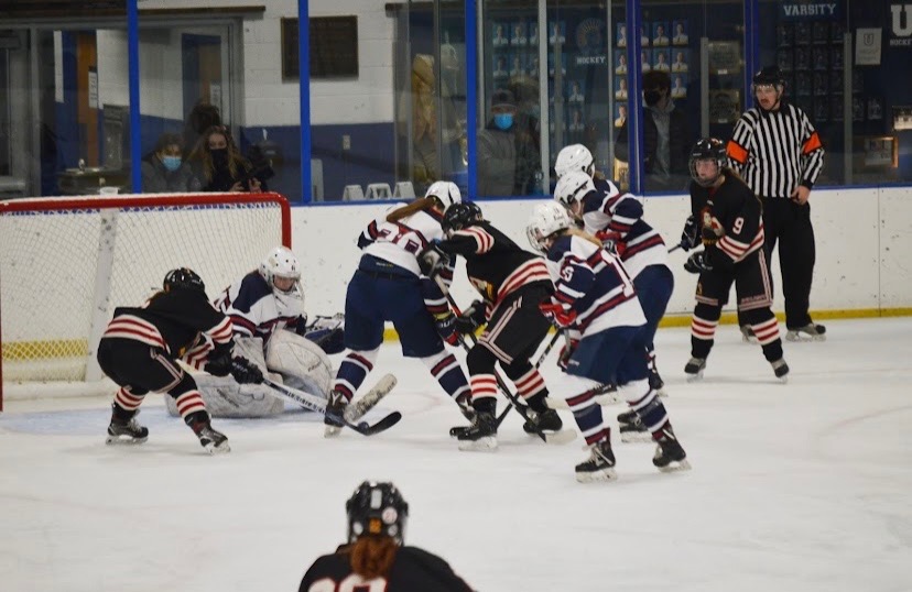 DEFEND THE GOAL. Goalie Greta Magnuson gets ready to block a shot as the defense crashes the net. "The new co-op didn't affect the team too much because we have the same amount of friendship and chemistry as we did before," Magnuson said. The defense and Magnuson worked together to successfully block the shot. 