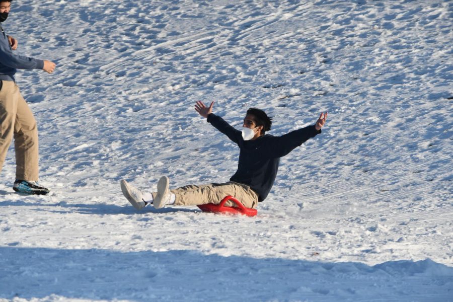 ALL HAIL WINTER. Warm from sledding, Senior Mukeil Rizvi enjoys spending time with his friends out on the hill.