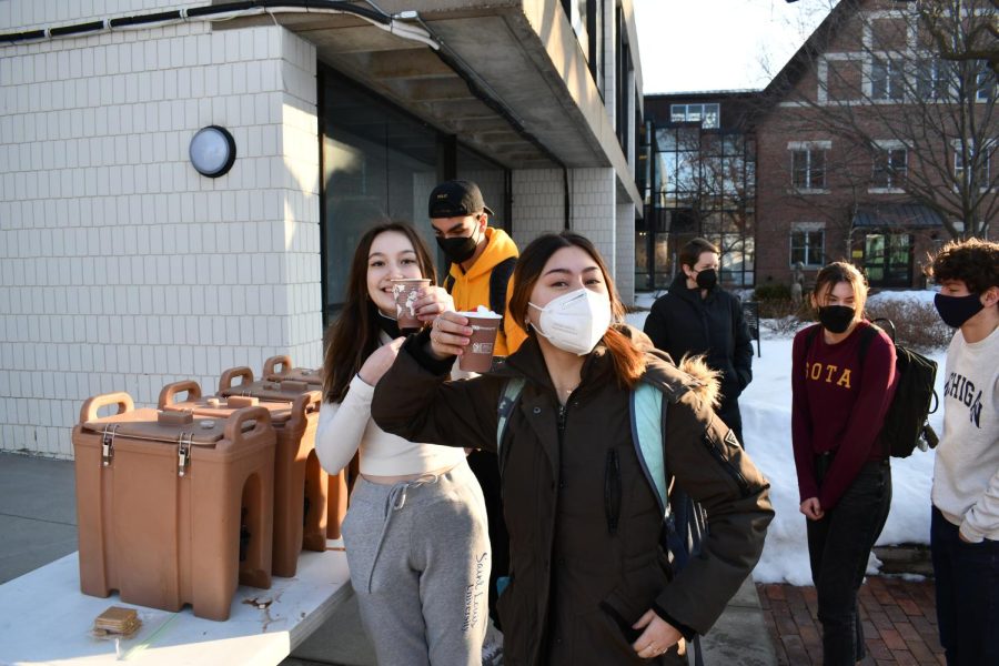 HOT CHOCOLATE. Seniors Olivia Szaj and Sarina Charpentier grab a hot chocolate as they wait for the sledding to begin during X period. 