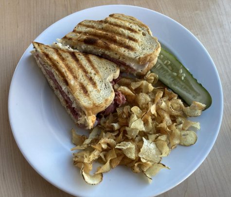 The Reuben sandwich was salty and tender, with a side of crispy potato chips and a tangy pickle.