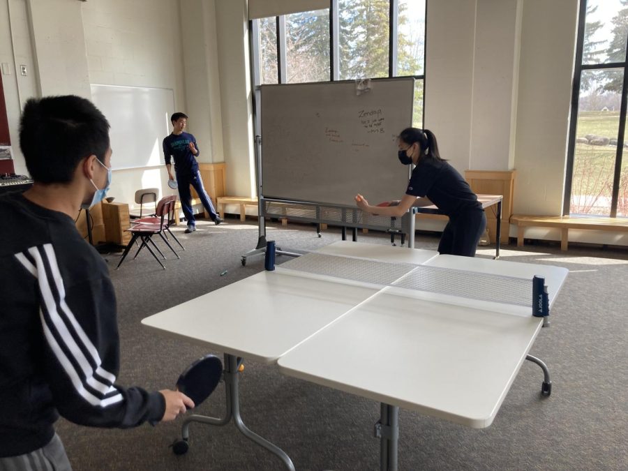 Sophomore Rita Li prepares to serve the ball, on a makeshift table.