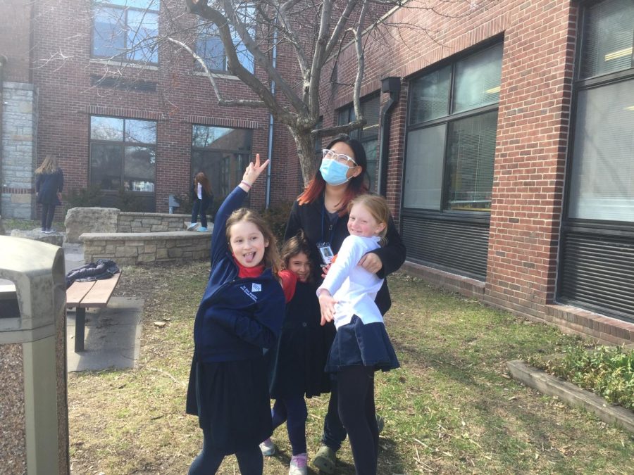 STRIKE A POSE. Lower Schoolers pose with senior Nan Besse, making a quick snapshot into a photo shoot.