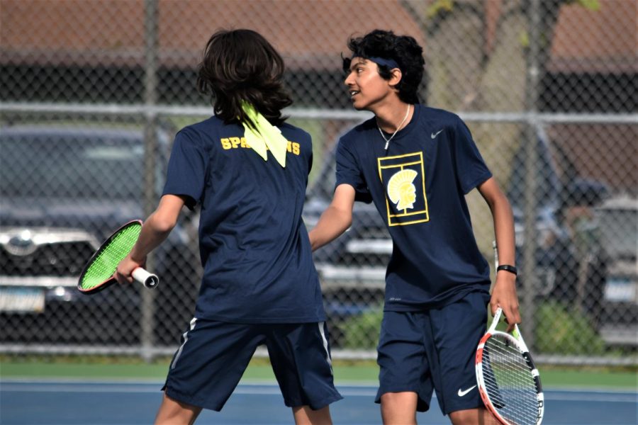 [STRIKING VOLLEY] Freshman Jacob Colton high-fives sophomore Baasit Mahmood after a strong finish to a point.