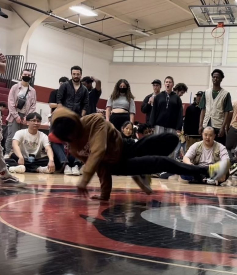 ROUND AND ROUND. Masumi Kouakou does a 360 on the ground as the crowd observes. He feels comfortable dancing at his studio, because metaphorically, he feels that they "all are in the same room.”