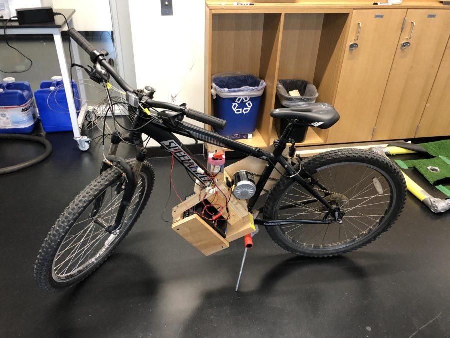 WORKING HARD. McKinnon used wood and duct tape to place the battery, motor, and motor controller onto the bike. He also placed switches on the motor controller to turn the motor off or on and the throttle on the handlebars, to simplify construction.