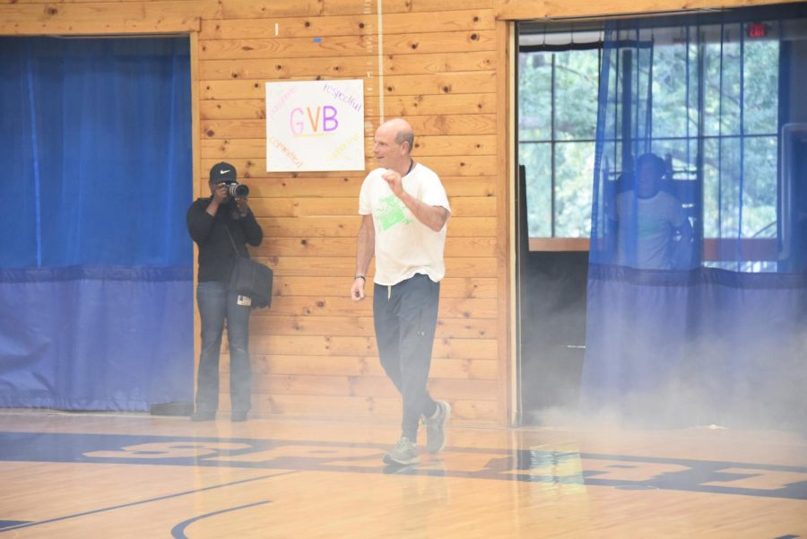 GRAND ENTRANCE. Upper School Principal Ken Jaffe waves to the crowd with a smoke machine running behind him. The teachers pulled out all the stops to make their introductions intense and exciting. 