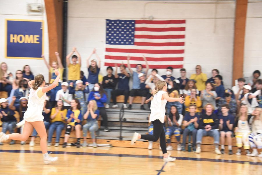 WHAT A WIN. Seniors Riley Erben and Solvej Eversoll race towards the crowd in celebration of a Graduation victory. The team boasted an athletic lineup that made their win over the teachers look easy. 