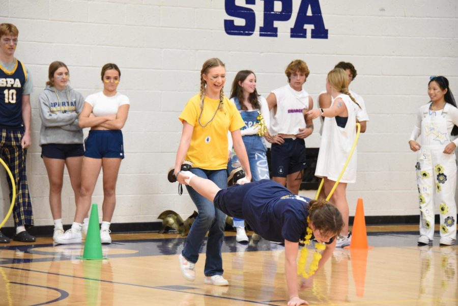 LOTS OF LAUGHS. Student Activities Committee members Kate Hanf and Clare Kimmel demonstrate the wheelbarrow race, a part of the grade-level challenge. 
