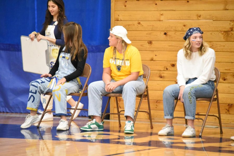 HEATED COMPETITION. One captain from each fall sport represents their team in the next challenge. In a version of musical chairs, participants must retrieve certain items from members of the audience and race back to get a seat in time. The trick? No speaking allowed. This year, Girls Volleyball took home the victory.