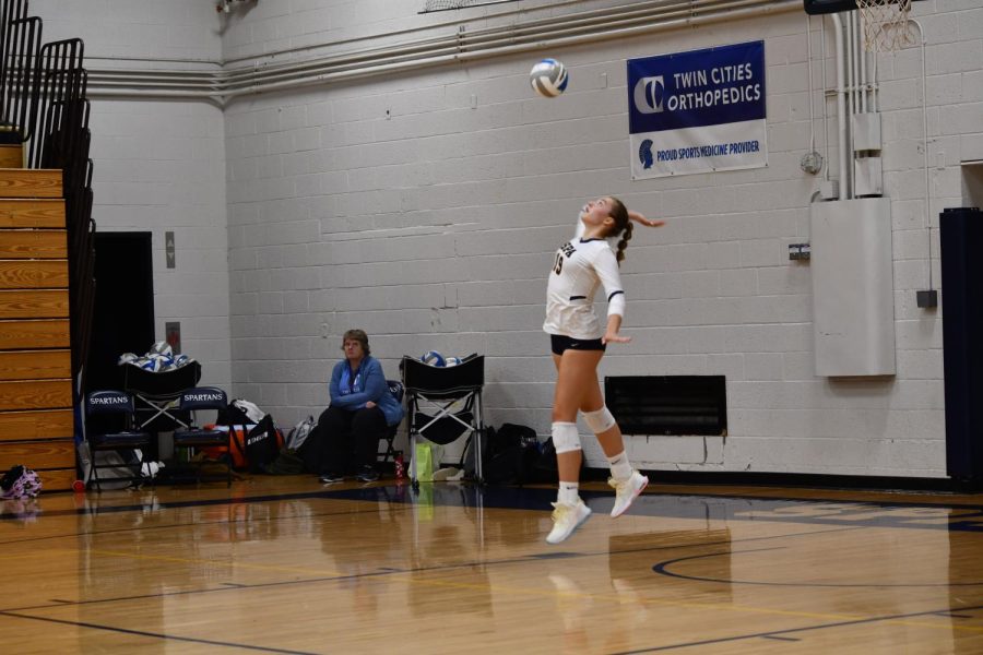 SERVES UP. Senior Solvej Eversoll leaps up to serve in GVV’s game against Breck on Sept. 16.