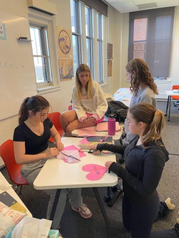 HERSPACE. Freshmen Raina Heidkamp, Charlotte Talbot, Lilly Spurgeon and Laura Kimmel cut out paper hearts during a HerSpace meeting to plan for Love Your Body Day. We were making decorations for the HerSpace board, Heidkamp said. It was really fun and it was chill.
