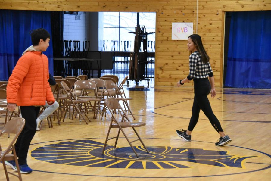 CIRCLES: Junior Rita Li and Freshman Thomas Chen race around the last chair.