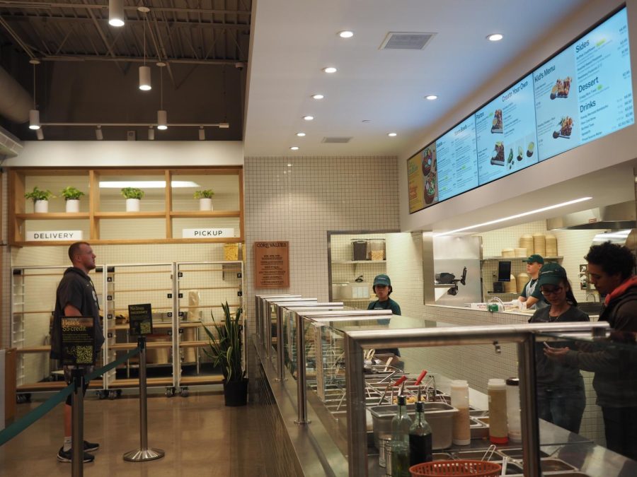 FLAWLESS AND FUNCTIONAL. As guests enter the restaurant facility, they are met with a clean, cohesively decorated space that is organized to optimize function. There is an order lane, prompting guests to watch the staff make their meal in real time, a stool bar wall, and a large television screen displaying the menu. The space feels both open and inviting.