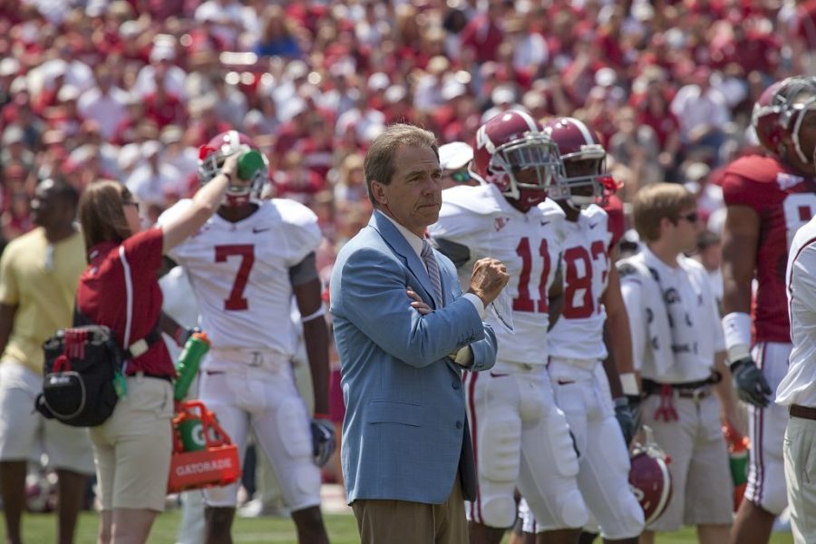 Coach Nick Saban watches his team scrimmage from the sideline.