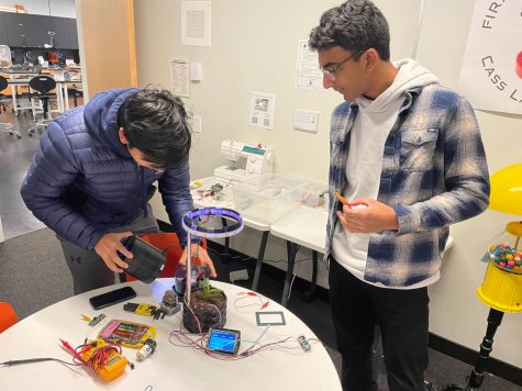 AIR PLANTER. Juniors Humza Murad and Rishi Bhargava make some last minute adjustments to their self-watering planter before class. “A lot of the process has been trial and error and learning from our mistakes,” Murad said.