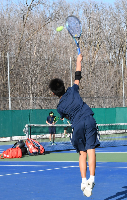 VARSITY DEBUT. Seventh grader Winston Arvidson starts a new match with a serve. This season is his first on the high school varsity team. “Its really nice to be on the team in seventh grade getting to know the older kids in high school and I think its a privilege to be on the team,” Arvidson said.
