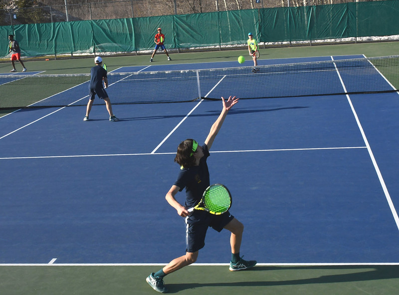 EYE ON THE GREEN. Sophomore Jacob Colton releases the ball from his hand, setting himself up for a solid serve nearing the end of their final match.
