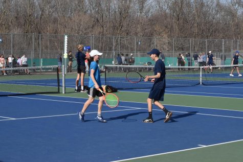 CHEERFUL REJOICE. Senior Dev Kharbanda and seventh grader Caleb Colton high-fives each other joyfully after a successful match at Wayzata High School. “I was feeling pretty nervous because it was my first varsity match, and I hadnt known I was playing until I was picked up from school.” Said Caleb. “During the match I just tried to stay as positive as I could.” 