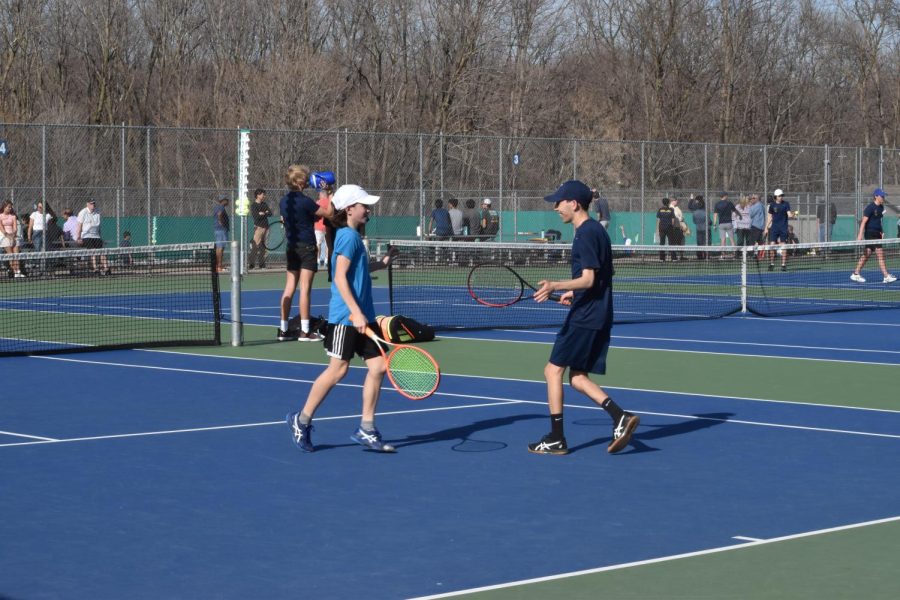 CHEERFUL REJOICE. Senior Dev Kharbanda and seventh grader Caleb Colton high-fives each other joyfully after a successful match at Wayzata High School. “I was feeling pretty nervous because it was my first varsity match, and I hadn't known I was playing until I was picked up from school.” Said Caleb. “During the match I just tried to stay as positive as I could.”